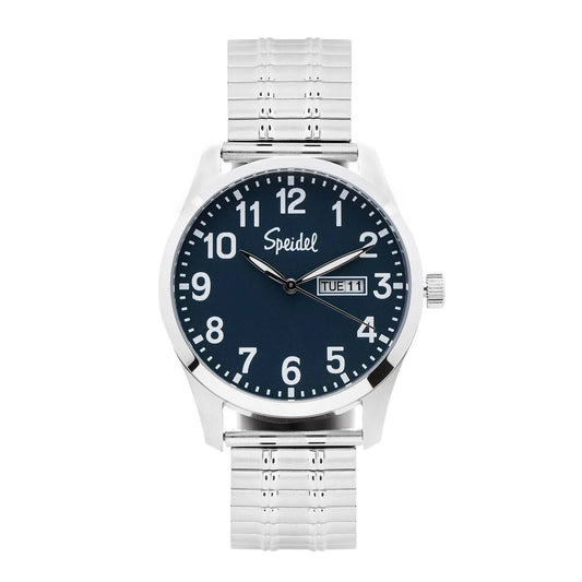The Speidel Watch - Essentials - 603392001 by Speidel features a silver case, blue face, white numbers, classic Twist-O-Flex band, and displays day and date in a window on the right side of the dial.