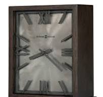 The Howard Miller Clock - Reid - 635-215 features a dark wooden rectangular frame, Roman numerals, black hands at 7:25, a brushed metal background, and quartz movement—an elegant accent for rustic décor from Howard Miller.
