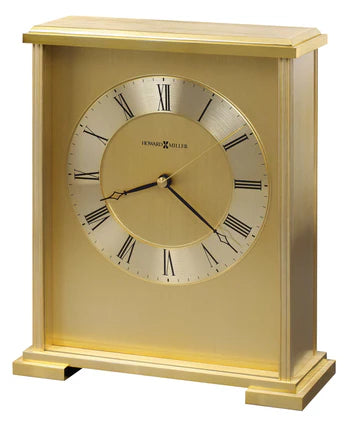 The Howard Miller Exton Tabletop Clock (645-569) features a rectangular brass design with Roman numerals and black hands—an elegant, upright decorative piece for any tabletop space.