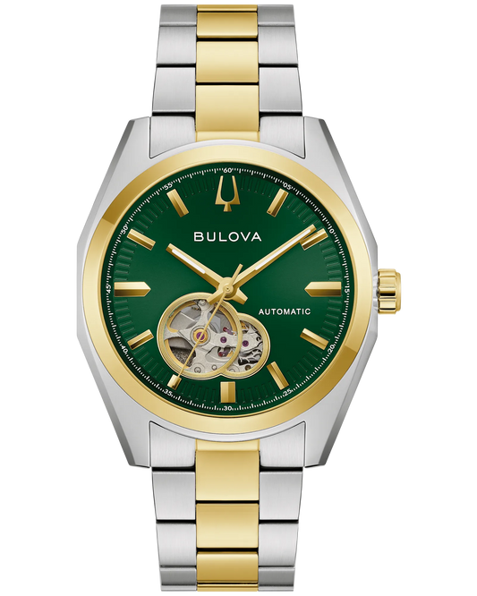 The Bulova Watch - Surveyor Automatic - 98A338 is a men’s automatic watch with a two-tone stainless steel band, a green dial with gold hour markers, and an open heart window at the 8 o’clock position.