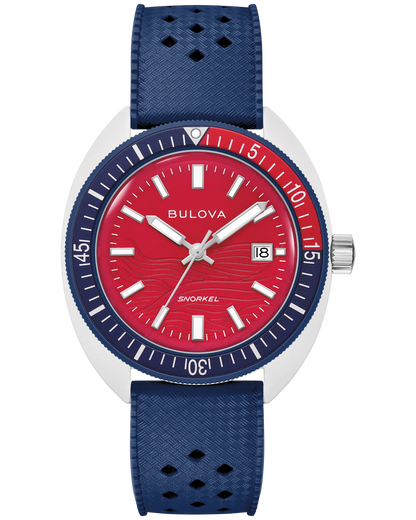 The Bulova Watch - Snorkel July 4th - 98B474 features a red dial, white hour markers, date window at 3 o’clock, blue bezel, and perforated blue textured strap.