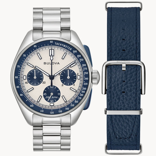 The Bulova Lunar Pilot 98K112 is a silver chronograph watch with a cream and blue dial, silver bracelet, and extra textured blue leather strap. Powered by high-precision quartz movement for exceptional accuracy.