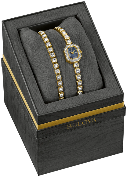 A Bulova Watch - Crystal Box Set - 98X143, featuring a gold women’s watch and matching bracelet adorned with Austrian crystals and a mother-of-pearl dial, is displayed on a black cushion inside an elegant black and gold Bulova box.