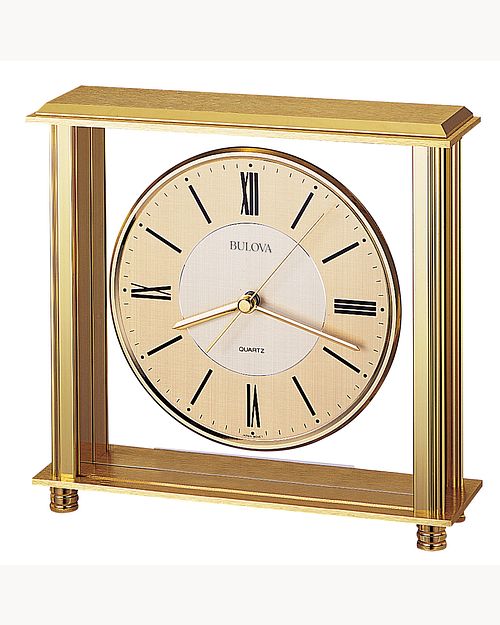 The Bulova Clock - Grand Prix - B1700 features a gold-tone brass finish, Roman numerals, black hands, and a textured cream dial in a rectangular frame. Includes an optional engraving plate. Brand: Bulova.
