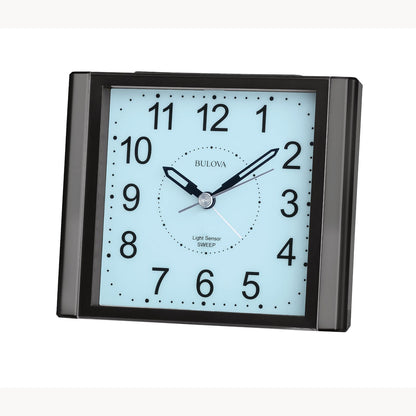 The Bulova Clock - EZ View - B1872 is a square black clock with a light blue face, black numbers, and three hands showing 1:10:08. It features “Light Sensor SWEEP,” silent sweep quartz movement, and modern design for quiet operation.