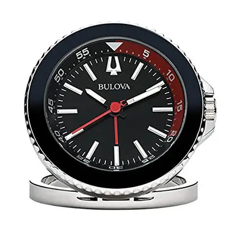 The Bulova Clock - Diver Desktop - B6125 is a round travel clock with a black face, silver hour markers, red second hand, white hands, a silver border, and a shiny silver base. Brand: Bulova.