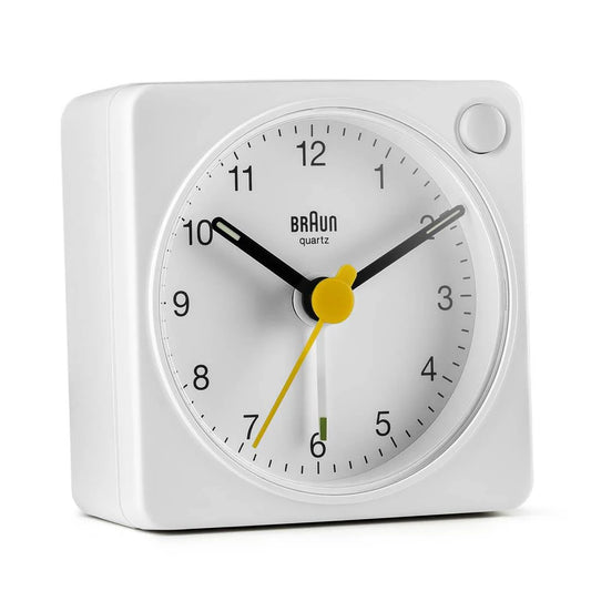 The Braun BC02XW Travel Alarm Clock by Ameico features a white case, black hour and minute hands, a yellow second hand, and center circle. Its compact, minimalist design displays the time as 10:10:36—ideal for modern travelers.
