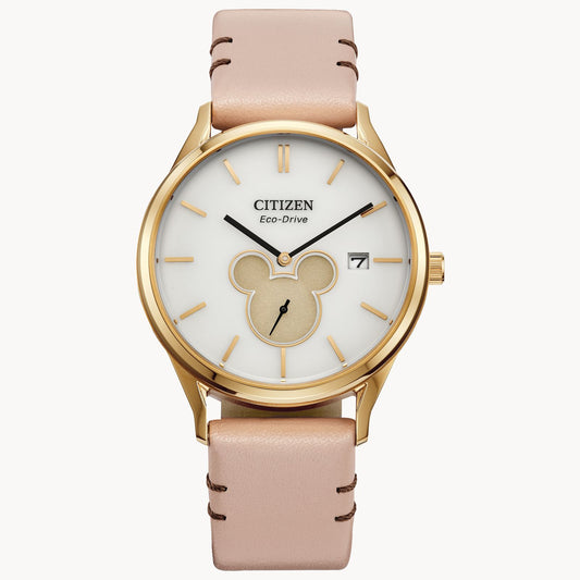 The Citizen Watch - Mickey Shadow (BV1132-08W) features a gold case, light pink leather band, white dial with gold accents, Mickey Mouse silhouette above 6 o’clock, and a date display near 3 o’clock.