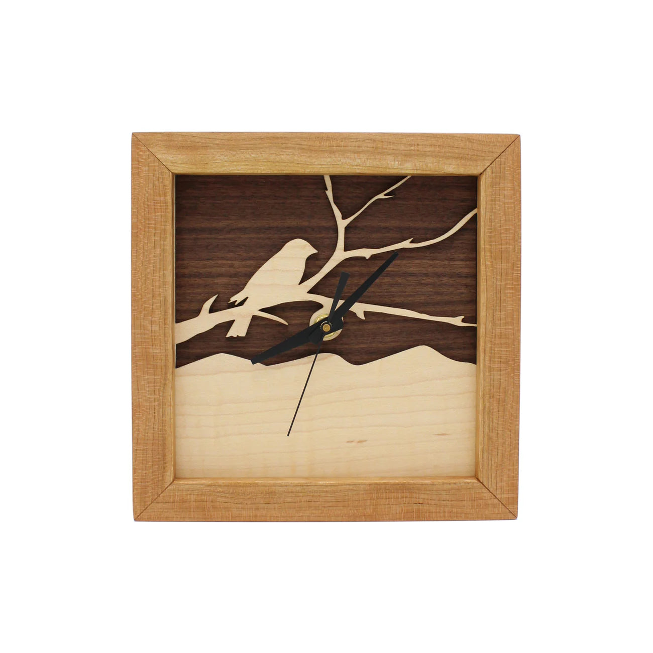 The Sabbath Day Woods - Bird on a Branch Walnut & Maple Box Clock features a handcrafted square design with a bird-on-branch silhouette, black hands, and sustainable walnut and maple wood for timeless style.