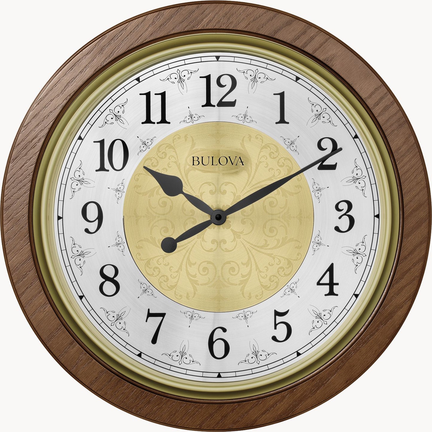 The Bulova Clock - Manchester (C4115) features a round brown wood frame, black Arabic numerals and hands, a gold center design, and the Bulova logo. It shows 9:10 and includes Harmonic II PLUS chiming movement.