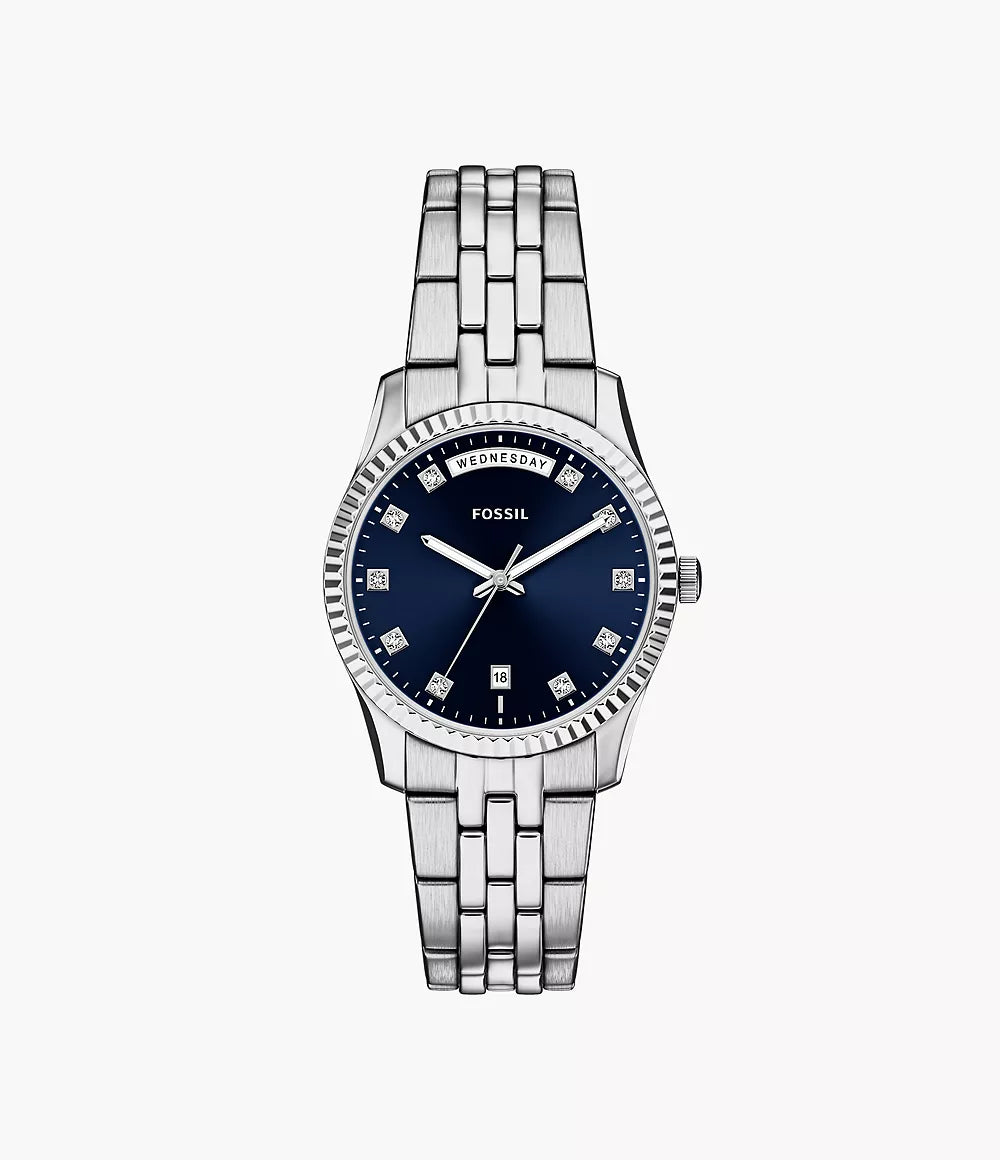 The Fossil Watch - Scarlette - ES5457 features a stainless steel link band, dark blue dial, silver hands, diamond-like markers, date at 6 o’clock, and day display at 12 o’clock, shown on a white background. Brand: Fossil.