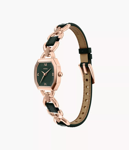 A Fossil Harlow ES5498 wristwatch featuring a rose gold-tone case, black rectangular dial with Roman numerals, and a black leather strap adorned with rose gold chain links and a buckle clasp.