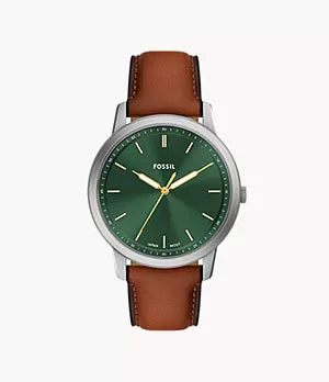 The Fossil Watch - Minimalist - FS6094 features a green dial, gold hands, silver case, and brown leather strap, shown against a white background.