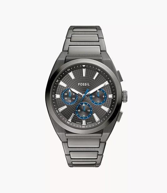 The Fossil Watch - Everett - FS6107 is a men’s sporty silver chronograph with a stainless steel band, black textured dial, blue-accented subdials, silver hour markers, and three side buttons by Fossil.