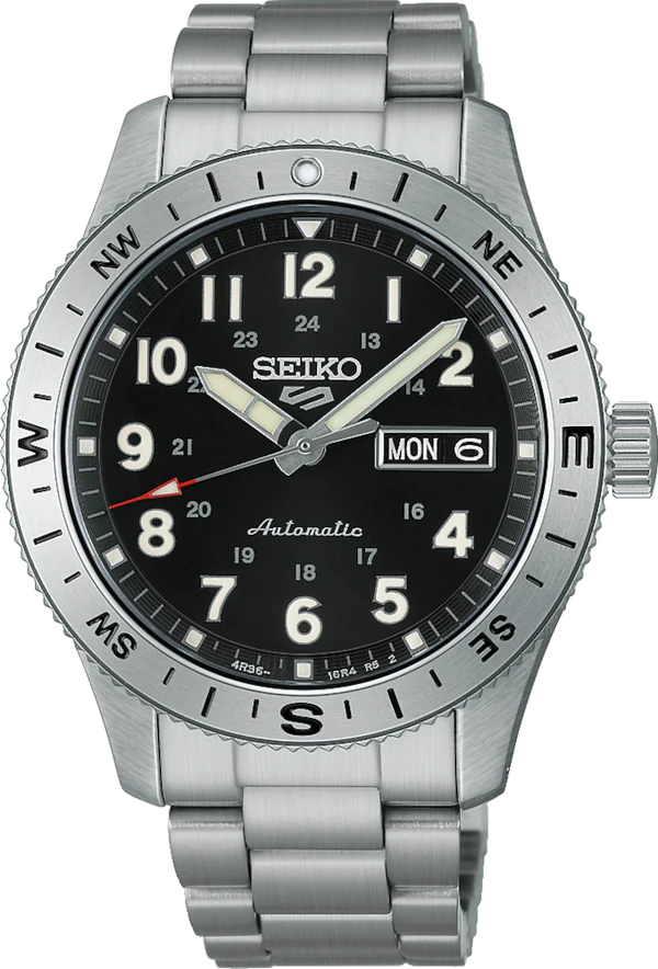 The Seiko Watch - Seiko 5 Automatic - HDB006 by Seiko features a black dial with white numerals, silver compass bezel, day-date window on the right, automatic movement, and a stainless steel bracelet.