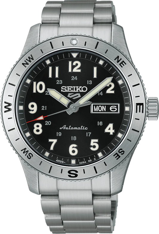 The Seiko Watch - Seiko 5 Automatic - HDB006 by Seiko features a black dial with white numerals, silver compass bezel, day-date window on the right, automatic movement, and a stainless steel bracelet.