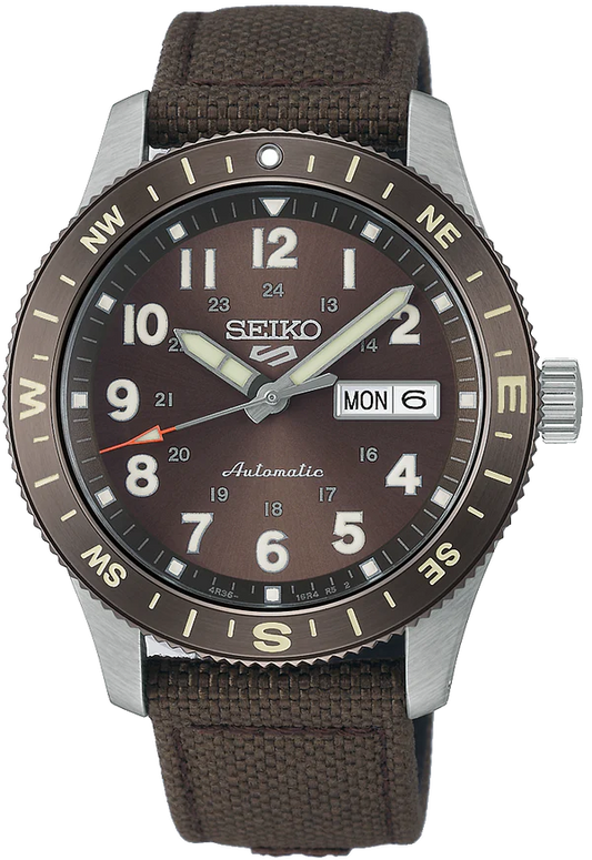 The Seiko Watch - Seiko 5 Automatic - HDB009 by Seiko features a brown dial, silver hands and markers, day-date at 3 o’clock, compass bezel with beige lettering, automatic movement, and a brown fabric strap.