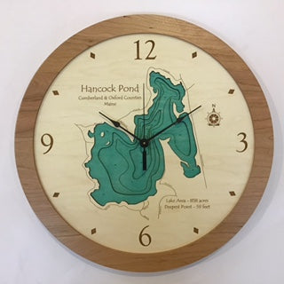 The Lake Art Lake Clock - Hancock Pond is a custom wooden wall clock featuring a topographic map of Maine’s Hancock Pond with water depths in blue and green, wood accents, black hands, and detailed map markings.