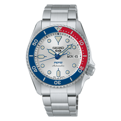 The Seiko 5 x Pepsi® Limited Edition SRPL99 is a silver automatic watch with a white dial, Pepsi blue and red bezel, silver hour markers, stainless steel band, and day-date display; Pepsi and Automatic are printed on the face.