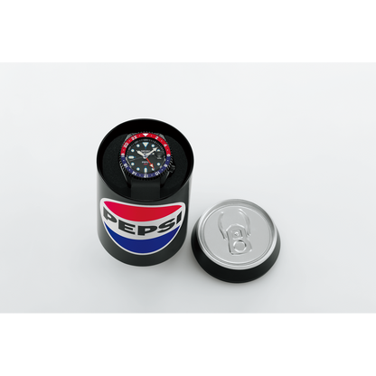 The Seiko 5 x Pepsi® Limited Edition SSK047 automatic watch with a red and blue bezel is displayed inside an open black can featuring the classic Pepsi logo, with the lid placed beside it on a white surface.