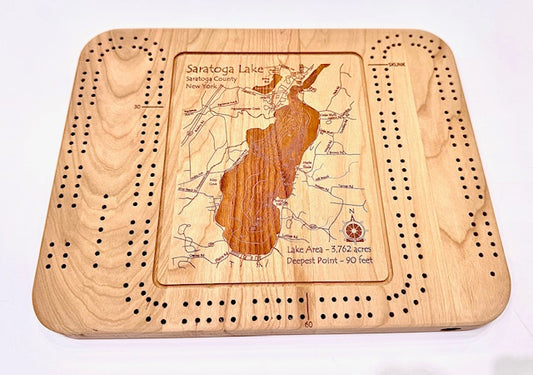 The Lake Art Lake Gift - Saratoga Lake Cribbage Board features an engraved map of Saratoga Lake, its area (3,762 acres), deepest point (90 ft), and peg holes around the detailed wooden design—perfect for lake and cribbage lovers.