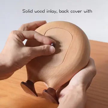 A person holds the Senser Woodcraft - Big Foot Clock - LL56, featuring a solid wood inlay and two small legs, while opening its back cover. This handcrafted piece by Senser Woodcraft rests on a wooden surface. Text above reads: Solid wood inlay, back cover with.