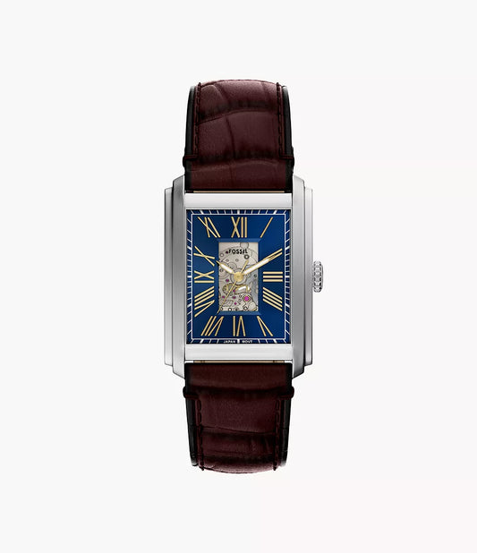 The Fossil Watch - Carraway Automatic - ME3273 by Fossil features a brown leather strap, blue skeleton dial with gold Roman numerals, visible gears, and a silver case, shown from above on a white background.