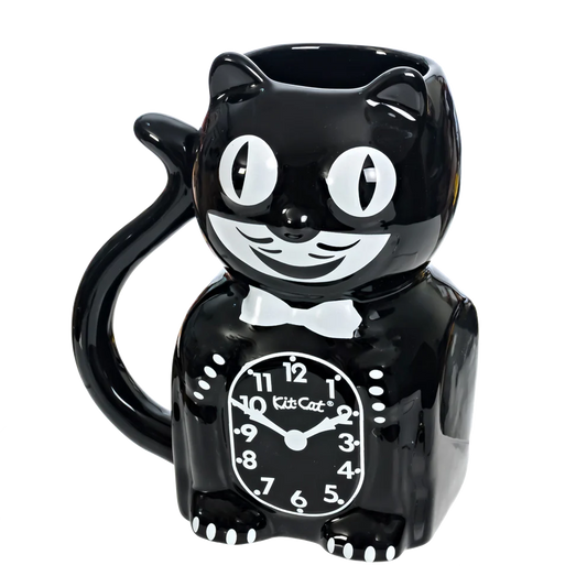 The California Clocks Kit-Cat 20oz Mug (KC-MG-1) features a glossy black ceramic design shaped like a smiling cartoon cat with big eyes, a bow tie, and a clock face on its belly. The handle is the curled tail, inspired by the classic Kit-Cat Klock.