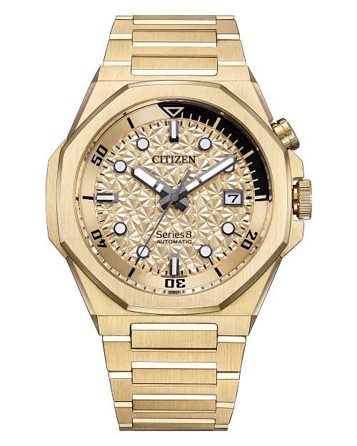 The Citizen Watch - Series8 890 City Lights (NB6062-52P) features a gold-tone stainless steel case, patterned dial with geometric markers, date at 3 o'clock, two crowns, automatic movement, and a gold bracelet for added luxury.