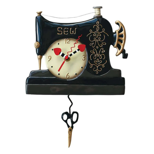 The Enesco Allen Designs Vintage Stitch Sewing Machine Clock (P1752) features SEW at the top, a central clock face, and pendulum scissors—an ideal sewing-themed gift for crafters and collectors.