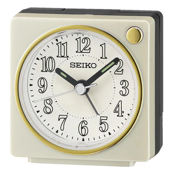 The Seiko Clocks - Bedside Alarm - QHE197WLH features a square design, quartz movement, white face, black numbers and hands, gold trim accents, silver alarm hand, and a round gold button—ideal as a bedside clock.