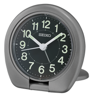 The Seiko Clock - Sakai Metallic Dark Silver (QHT018T) is a round, gray travel alarm clock with white numbers, hands at 10:10, a black face, foldable stand, and precise quartz movement set against a plain light background.