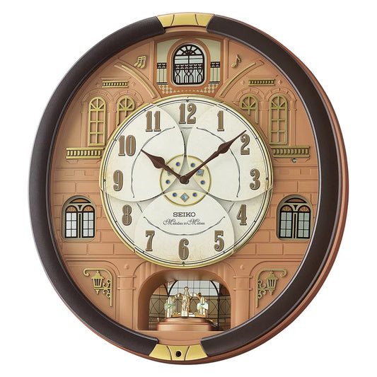 Seiko's Melodies in Motion Clock with a brown metal case, white dial, and decorative elements such as rotating ornament on the dial and a pendulum with Swarovski crystals.
