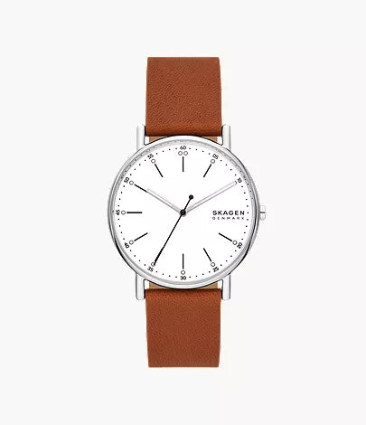 The Skagen Watch - Signatur - SKW6903 by Fossil features a white dial, silver case, minimalist black markers and hands, the SKAGEN Denmark logo, and a brown leather strap for timeless style.
