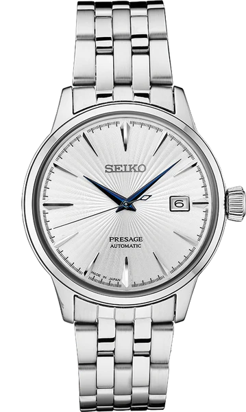 The Seiko Watch - SRPB77 - Seiko Presage by Seiko is a stainless steel watch with a silver sunburst dial, blue hands, black hour markers, and a date display at 3 o’clock.