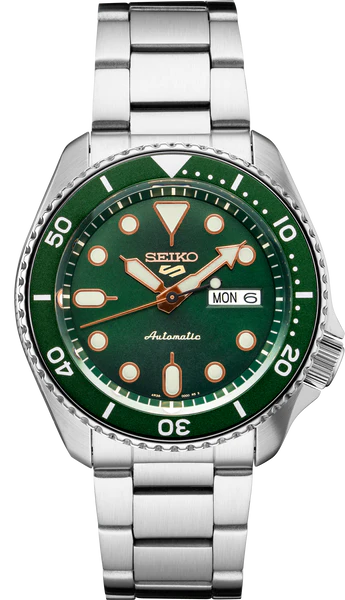 The Seiko 5 Sports SRPD63 by Seiko features a green bezel and dial, silver hour markers with gold accents, stainless steel bracelet, and displays the day and date set to Monday the 6th.