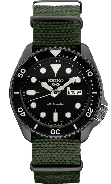 The Seiko 5 Sports SRPD91 by Seiko features a black dial with white markers, luminous hands, white-marked bezel, green fabric band, day-date display, and is water resistant up to 100 meters.