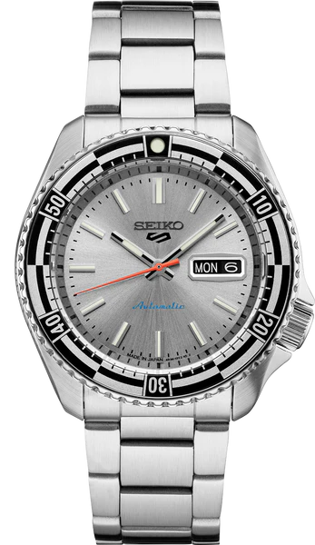 The Seiko 5 Sports 55th Anniversary Special Edition SRPK09 is a silver automatic watch with a stainless steel band, black bezel, gray dial, luminous markers, day-date at 3 o’clock, and a bold red seconds hand.