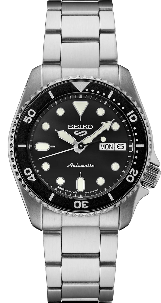 The Seiko 5 Sports SRPK29 is a stainless steel automatic watch with a black dial, luminous markers, rotating bezel, and day-date display at 3 o’clock. The mid-size SKX design shows 10:09 with Monday set on the day display.