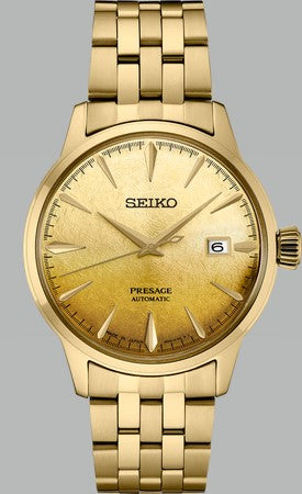 The Seiko Presage Cocktail Time SRPK46 automatic watch features a textured gold dial, gold markers and hands, a date display at 3 oclock, and a gold bracelet—showcasing Japanese watchmaking against a gray background.