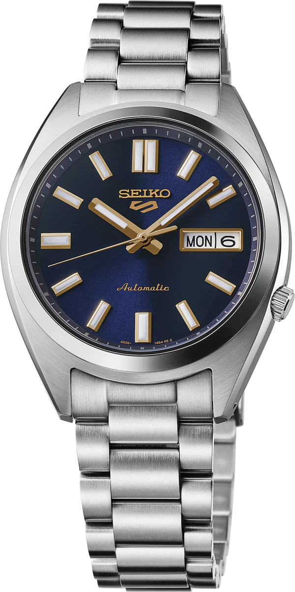 The Seiko 5 Sport SRPL55 automatic watch features a stainless steel band, dark blue dial, gold markers and hands, plus a day-date display (MON 6) at the 3 o'clock position.