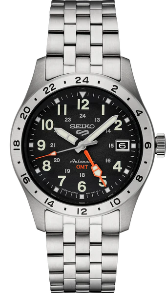 The Seiko 5 Sports Field GMT SSK023 is a stainless steel automatic watch with a black dial, silver hour markers, date at 3 oclock, orange GMT hand, 24-hour bezel markings, and a metal link bracelet for a sporty look.