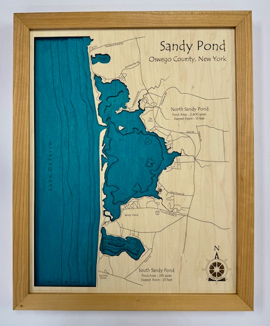 The Lake Art Lake Map - Sandy Ponds Oswego County NY is a 14" x 18" laser-carved wooden relief map with engraved labels for North and South Sandy Pond, local roads, a compass rose, and blue water areas—ideal as a lake map clock display.