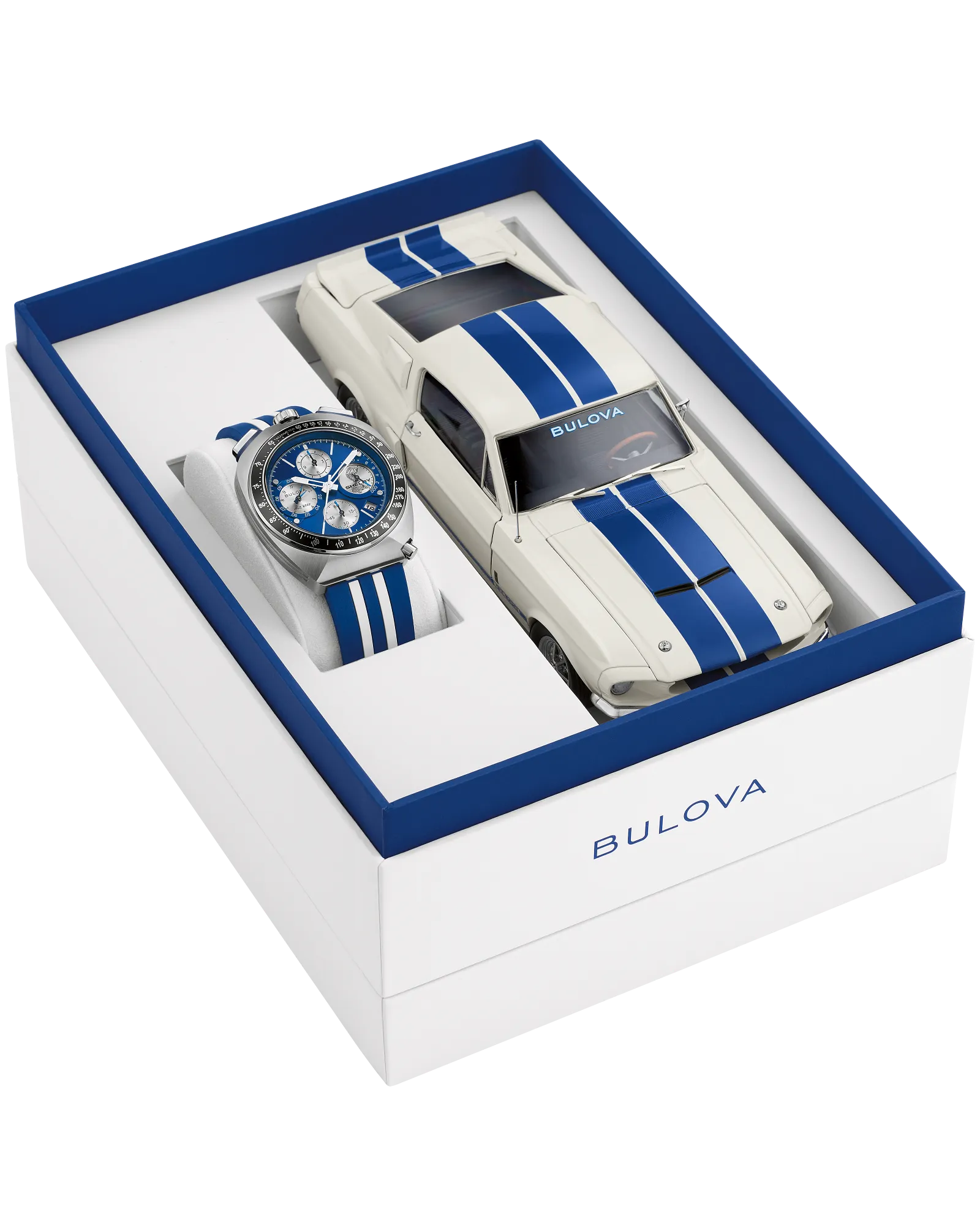 The Bulova Shelby Racing Chronograph (98B452) gift set includes a blue and white limited-edition watch and a matching white model car with blue stripes, both in an elegant box with blue accents and the Bulova logo.