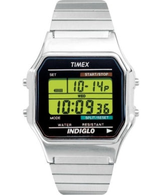 The Timex Watch - Classic Digital - T785829J by Timex shows the date 10-14 and time 10:09:36 on its green LCD, features start/stop and split/reset buttons, and has an Indiglo backlight.