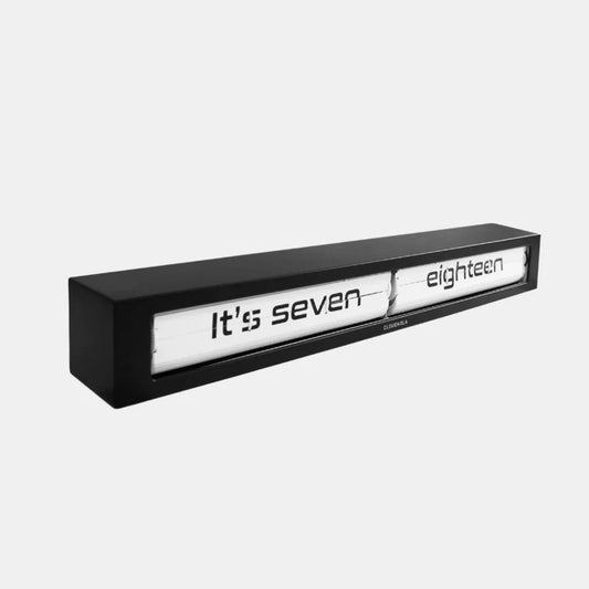 The Cloudnola Texttime Black Flip Clock (0072) displays the time in words, such as "It's seven eighteen," on a white background, bringing a modern touch to any room.