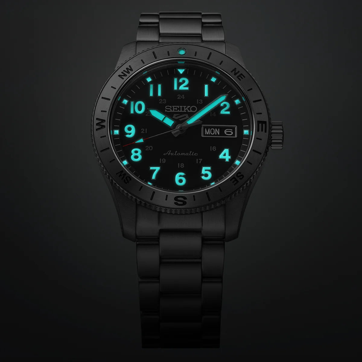 The Seiko 5 Field Series HDB008 wristwatch by Seiko features a durable black metal band and displays luminous blue hour markers and hands for visibility in the dark. This robust automatic field watch also includes a day and date window positioned on the right side of the dial.