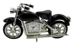 The Sanis Enterprises Sanis Mini Clock - Motorcycle Blk - C263BK is a black desk clock designed in the shape of a classic motorcycle, featuring a functional clock face embedded in the body.