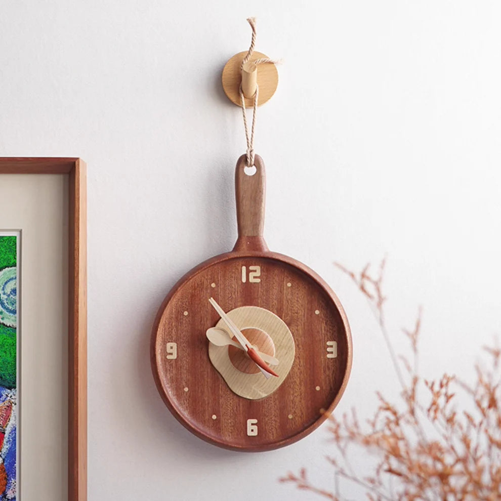 The Senser Woodcraft - Wooden Wall Clock - Sunny Side Up - LL04 by Senser Woodcraft, designed to look like a frying pan with light-colored hands and numbers, makes a perfect cozy kitchen centerpiece.