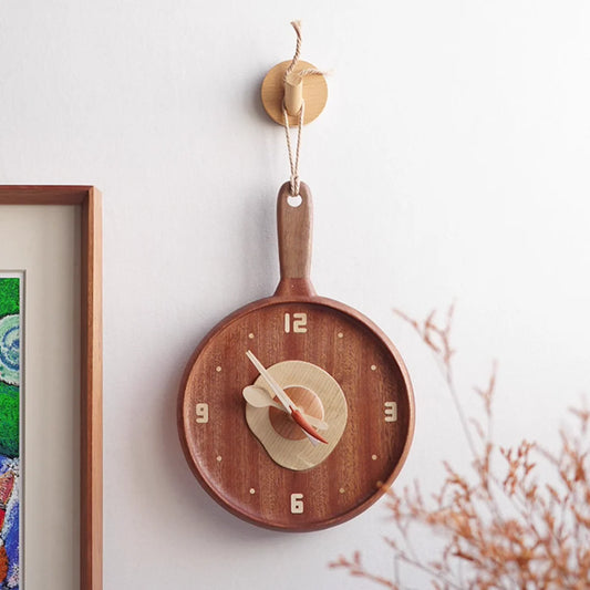 The Senser Woodcraft - Wooden Wall Clock - Sunny Side Up - LL04 by Senser Woodcraft, designed to look like a frying pan with light-colored hands and numbers, makes a perfect cozy kitchen centerpiece.